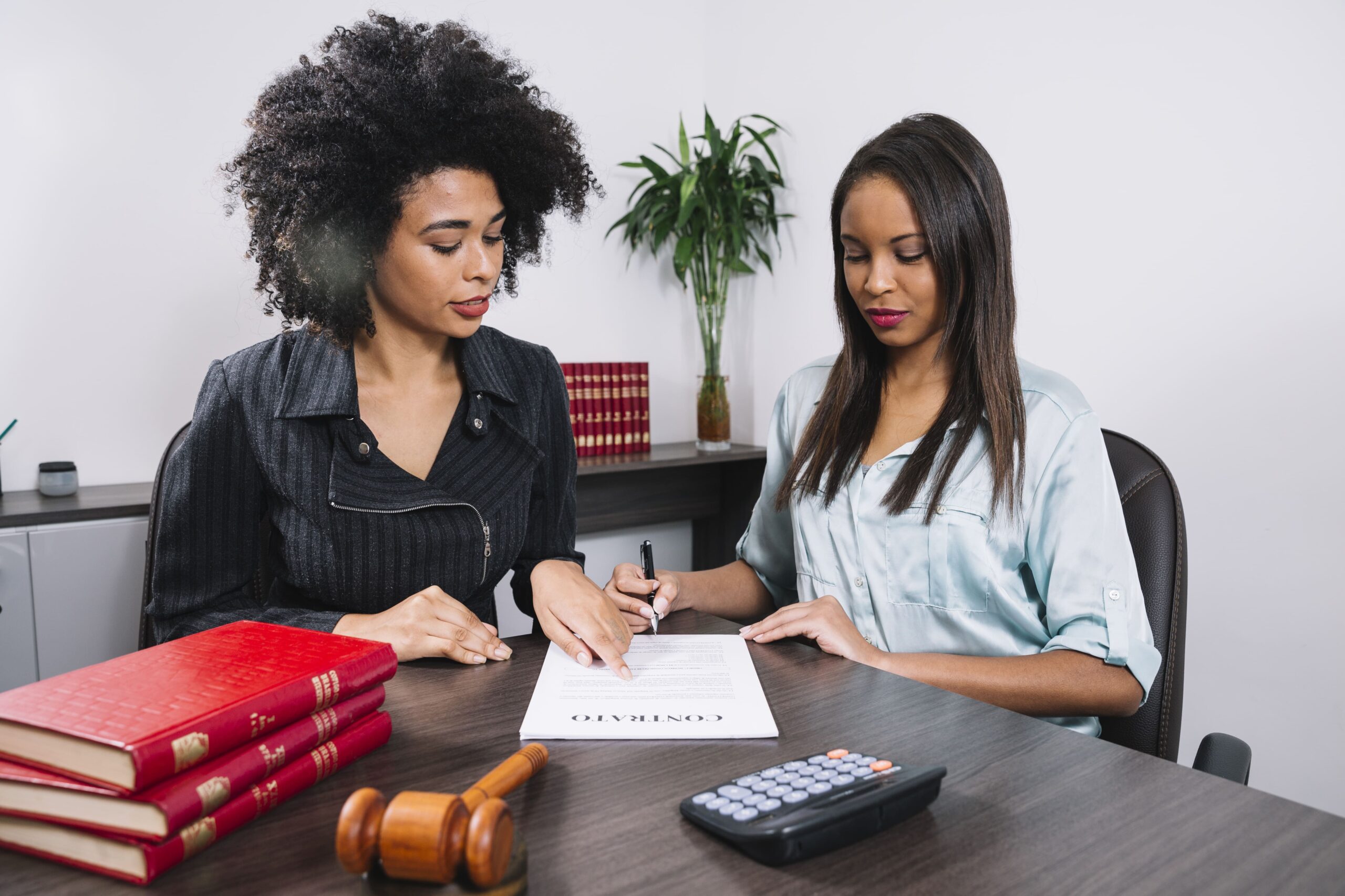 african american woman pointing document near lady with pen table(1)